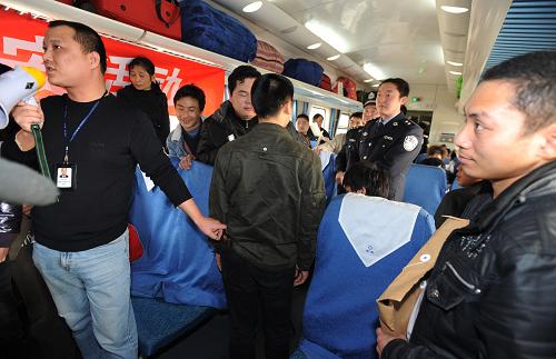 1月28日,在從廣州開往成都的K193次列車上,成都鐵路公安處乘警支隊(duì)民警陳軍(左一)為乘客演示反扒知識(shí)。新華社記者 江宏景 攝