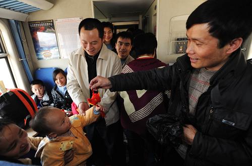 1月28日,在從廣州開往成都的K193次列車上,成都鐵路公安處民警向旅客贈(zèng)送小禮物。新華社記者 江宏景 攝