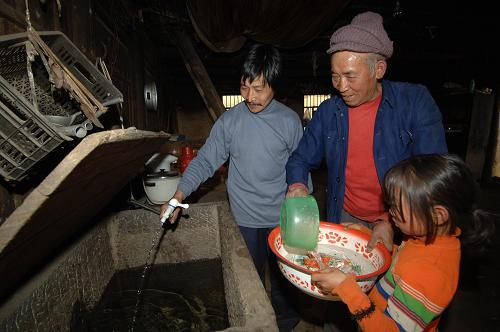 武隆縣殷桃坪村村民李光發(fā)(中)家的儲水池盛滿了泉水(3月21日攝)。新華社記者 陳誠 攝