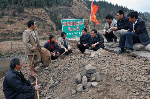 這是龍?zhí)舵?zhèn)黨委書記田春紅(中)、鎮(zhèn)長田飛(左四)在剛建起的“連心壩”上商談有效調(diào)控用水問題(3月26日攝)。新華社記者 何俊昌 攝