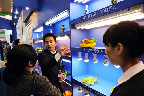 參展的廈門光電企業(yè)代表(左二)在向客商介紹家用節(jié)能照明產(chǎn)品(4月8日攝)。新華社記者 姜克紅 攝