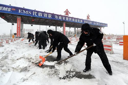 4月13日,哈同公路(哈爾濱至同江)管理處金家收費(fèi)站的工作人員在清理路面積雪。新華社記者 李勇 攝
