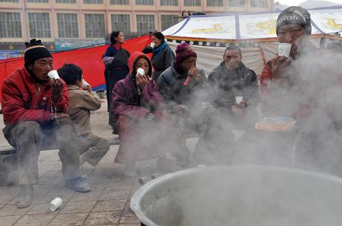 4月16日,群眾在街頭領(lǐng)取到免費發(fā)放的稀飯。震后第三天的早晨,記者在玉樹縣結(jié)古鎮(zhèn)街頭看到,消防、武警及當?shù)厝罕娋o張而有序地開展各項工作,隨著大批救災物資、人員的進駐,將有更多的災區(qū)群眾得到救援、救治、安置。新華社記者 王鵬 攝