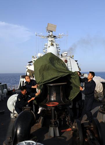 5月16日,“廣州”艦戰(zhàn)士為裝備套上防護(hù)外罩。新華社記者 劉春暉 攝