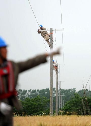 5月27日,肥西供電公司嚴(yán)店供電所的職工在巢湖岸邊架設(shè)排澇專用線路。進(jìn)入汛期以來(lái),安徽省電力部門加強(qiáng)各地電力排澇線路的檢修和維護(hù),對(duì)各地排澇站電力設(shè)備運(yùn)行進(jìn)行排查,在沿河、湖地區(qū)架設(shè)抗旱排澇電力專用線路,保障汛期電力供應(yīng)安全,確保安全度汛。新華社記者 劉軍喜 攝