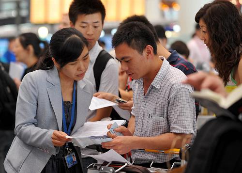 6月17日,乘客在首都機(jī)場T3航站樓查問航班消息。新華社記者 羅曉光 攝