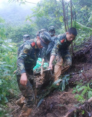 6月16日,武警賀州市支隊官兵將遇難者遺體抬出林場。新華社發(fā)