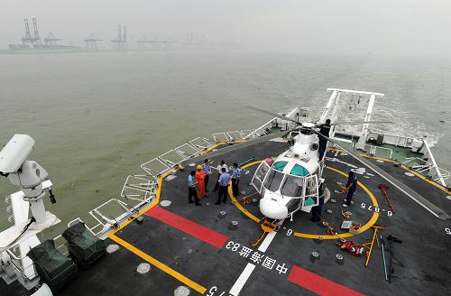 5月30日,船員在中國“海監(jiān)83”船上折疊直升機機翼,準備將直升機推入機庫內(nèi)。