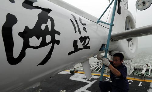 5月30日,機組曹偉民在中國“海監(jiān)83”船上折疊直升機機翼,準備將直升機推入機庫內(nèi)。 新華社記者 金良快 劉華攝影報道