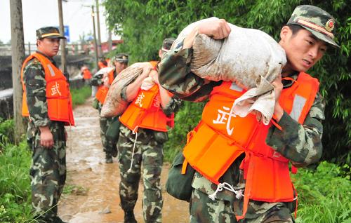 7月14日,武警合肥指揮學(xué)院官兵正在搬運(yùn)沙袋。當(dāng)日,安徽池州長江支流秋浦河殷匯鎮(zhèn)集鎮(zhèn)段秋浦河大橋以北200米處發(fā)現(xiàn)一處管涌,情況危急?,F(xiàn)場(chǎng)負(fù)責(zé)巡查的武警合肥指揮學(xué)院120名官兵迅速組織搶險(xiǎn),經(jīng)過一個(gè)多小時(shí)的雨中奮戰(zhàn),成功排除險(xiǎn)情。新華社發(fā)(胡超群 攝)