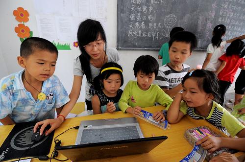 7月14日,支教大學生王立玲(左二)在用電腦給孩子講解相關(guān)的計算機知識。浙江工業(yè)大學人文、機械、藝術(shù)等專業(yè)的10名大學生,利用暑期來到浙江省衢州市嶺洋鄉(xiāng)希望小學,為這里的山區(qū)留守兒童開展暑期支教活動。嶺洋鄉(xiāng)地處山區(qū),交通非常不便,該鄉(xiāng)的青壯年勞動力一般都在外打工,而孩子們則大多與老人留在家里。來此支教的大學生克服多種困難,為孩子們開設(shè)了繪畫、詩詞、體育、百科知識普及、音樂等課程,讓山區(qū)的留守兒童們開闊了眼界,度過一個快樂充實的暑假。新華社記者 徐昱 攝