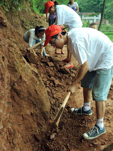 7月26日,大學(xué)生和村民一起在重慶市南川區(qū)大觀鎮(zhèn)參加村里修路勞動。新華社記者 周衡義 攝