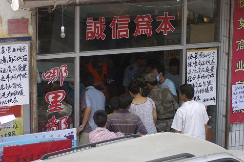 8月11日,在災(zāi)區(qū)現(xiàn)場(chǎng)一家恢復(fù)營(yíng)業(yè)的超市門(mén)口,救援官兵和當(dāng)?shù)厝罕娫谫?gòu)買水和食物。當(dāng)日,甘肅舟曲特大山洪泥石流災(zāi)害進(jìn)入第四天。繼8月8日第一家超市恢復(fù)營(yíng)業(yè)以來(lái),目前舟曲災(zāi)區(qū)已有32家商戶開(kāi)門(mén)營(yíng)業(yè),其中兩家為超市。新華社記者 高健鈞 攝