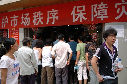 8月11日,在災(zāi)區(qū)現(xiàn)場(chǎng)一家恢復(fù)營(yíng)業(yè)的超市門(mén)口,當(dāng)?shù)厝罕娫谫?gòu)買水和食物。新華社記者 高健鈞 攝