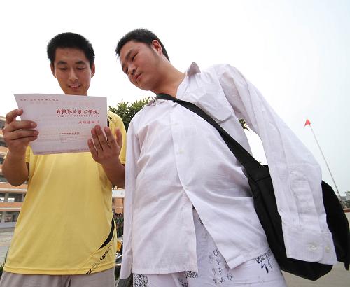 8月23日,無(wú)臂男孩戴軍頌(右)和同學(xué)一起觀看剛收到的新生錄取通知書(shū)。新華社發(fā)(胡衛(wèi)國(guó) 攝)