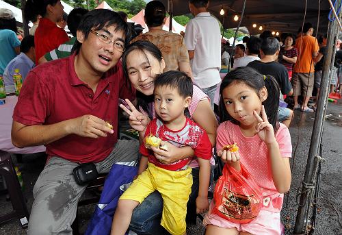 臺北市一家四口在“中秋樂紗帽山溫泉保育”活動上品嘗小吃(9月18日攝)。新華社記者 何俊昌 攝