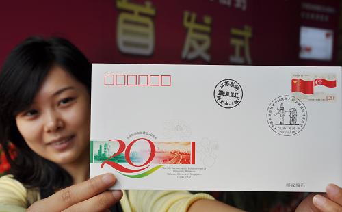 10月18日,一位集郵愛好者展示加蓋了郵戳的《中國和新加坡建交20周年》紀(jì)念郵資信封。當(dāng)日,《中國和新加坡建交20周年》紀(jì)念郵資信封在蘇州工業(yè)園區(qū)科技文化藝術(shù)中心首發(fā)。該套郵資信封1套1枚,信封郵票面值1.20元,發(fā)行量65萬枚。郵資信封郵資圖案主圖為中新兩國舞動的國旗,郵資信封主圖為蘇州工業(yè)園區(qū)現(xiàn)代大道與新加坡魚尾獅塑像。新華社發(fā)(朱桂根 攝)