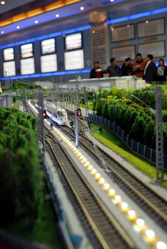 10月18日,人們在沈陽鐵路陳列館運輸能力展室參觀未來鐵路運輸?shù)纳潮P演示,模型動車組在沙盤上疾馳而行。新華社記者 徐揚 攝