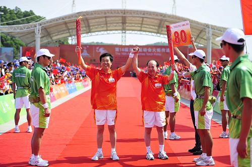 10月20日,亞運(yùn)會(huì)火炬?zhèn)鬟f汕尾站第79棒火炬手魏友莊(前左二)與第80棒火炬手龔俊龍(前左三)交接后合影。新華社記者 梁旭 攝