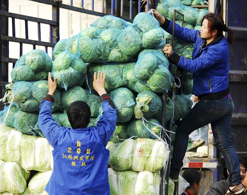 11月15日,菜商在上海江橋蔬菜批發(fā)市場(chǎng)搬運(yùn)蔬菜。新華社發(fā)