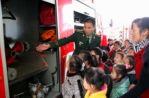 11月18日,在江西省靖安縣幼兒園,一名縣公安消防大隊(duì)的指導(dǎo)員向小朋友介紹消防車內(nèi)的滅火工具。新華社發(fā)(徐仲庭 攝)