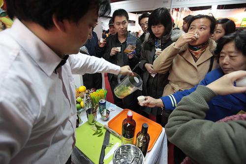 12月1日,在中國(guó)(北京)國(guó)際食品博覽會(huì)上,觀眾在品嘗加入檸檬的甘蔗酒。新華社發(fā)(羅偉 攝)