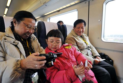 1月7日,來(lái)自廣州的郭思語(yǔ)小朋友(中)和外公、外婆一起體驗(yàn)廣珠城際鐵路列車。新華社記者 陳曄華 攝