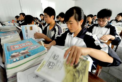 3月21日,盈江縣民族中學(xué)的初中學(xué)生在新建的防震活動板房教室里上課。新華社記者 陳海寧 攝