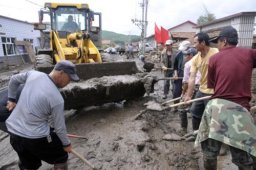 7月4日,在黑龍江省穆棱市下城子鎮(zhèn)新民村,救援人員在鏟除淤泥。新華社發(fā)(張春祥 攝)