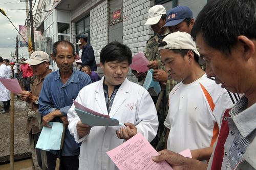 7月4日,在黑龍江省穆棱市下城子鎮(zhèn)新民村,疾控中心的工作人員向村民介紹災后防病知識。新華社發(fā)(張春祥 攝)