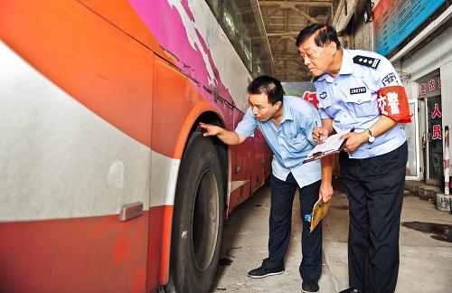 8月30日,天津交通集團天環(huán)客運站安檢員和駐站民警共同檢查客車輪胎狀況。新華社記者 張超群 攝