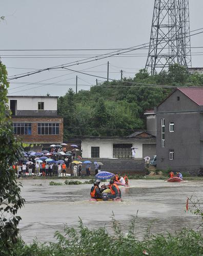 消防官兵正在緊急救援被困群眾(7月14日攝)。7月13日晚至14日,江西都昌縣出現(xiàn)罕見大暴雨,局部地區(qū)降水達(dá)200毫米以上。14日凌晨,在都昌縣大港鎮(zhèn)通浦、周上和劉皇3個村莊,山洪同時暴發(fā)。九江消防部隊(duì)隨即出動150名官兵,5艘沖鋒艇,3臺搶險救援車緊急趕赴現(xiàn)場。經(jīng)過6個小時奮力救援,消防官兵成功解救被山洪圍困群眾1300余人。新華社發(fā)(劉德生 攝)