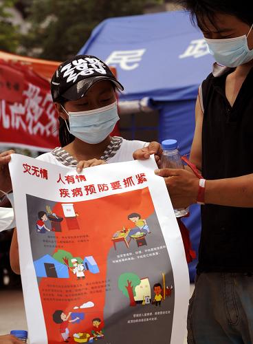 8月11日,兩名志愿者在災(zāi)區(qū)群眾安居點張貼衛(wèi)生防疫海報。當(dāng)日,在甘肅舟曲特大泥石流災(zāi)害救援現(xiàn)場,大規(guī)模、專業(yè)化的防疫工作全面展開,舟曲災(zāi)區(qū)醫(yī)療衛(wèi)生工作重點正由醫(yī)療救援轉(zhuǎn)向衛(wèi)生防疫。目前,災(zāi)區(qū)防疫人員已經(jīng)達(dá)到200余人,另有一大批青年志愿者加入到防疫宣傳行列。新華社記者 陶明 攝