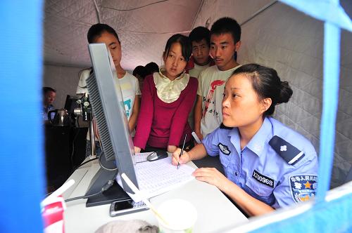 8月19日,在甘肅舟曲縣政府廣場(chǎng),舟曲縣公安局民警在帳篷內(nèi)為災(zāi)區(qū)群眾辦理身份證。當(dāng)日,在甘肅省公安廳幫助支持下,舟曲縣公安部門(mén)開(kāi)辟“綠色通道”,為在泥石流災(zāi)害中丟失了身份證、戶(hù)口的群眾24小時(shí)辦理身份證、戶(hù)口,保證辦證群眾隨到隨辦,7天之內(nèi)可取到身份證,現(xiàn)場(chǎng)就能辦好戶(hù)口,并且相關(guān)工本費(fèi)用全部免除。新華社記者 梁強(qiáng) 攝