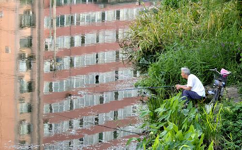 9月10日,一名老者在北京護城河邊釣魚,水面上倒映著附近住宅樓的影子。當日,國家統(tǒng)計局發(fā)布報告顯示,8月份全國70個大中城市房屋銷售價格同比上漲9.3%,漲幅比上月縮小1.0個百分點,環(huán)比與上月持平,這是7月份以來我國房價第二個月出現(xiàn)環(huán)比持平的情況。其中,8月份北京新建住宅銷售價格環(huán)比持平,二手住宅銷售價格環(huán)比下降0.2%。新華社發(fā)(樊甲山 攝)