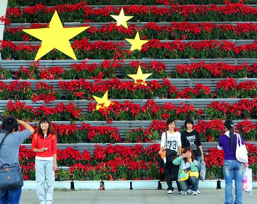 9月30日,游客在世博園區(qū)鮮花組成的國(guó)旗圖案前拍照留影。10月1日,上海世博會(huì)即將迎來(lái)中國(guó)國(guó)家館日。五星紅旗和大量鮮花盆景將世博園區(qū)裝點(diǎn)一新,營(yíng)造出濃濃的節(jié)日氛圍。新華社記者 徐昱 攝
