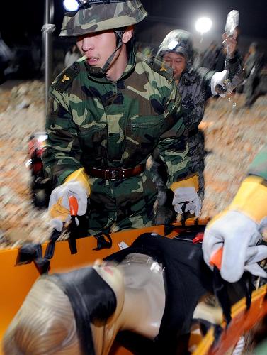 在抗震救災(zāi)應(yīng)急演練現(xiàn)場(chǎng),救援人員把“遇險(xiǎn)人員”抬向救護(hù)車(10月20日攝)。10月20日晚,遼寧省預(yù)備役高炮師在沈陽(yáng)郊區(qū)進(jìn)行了夜間抗震救災(zāi)應(yīng)急演練,演練主要分為多樣化任務(wù)器材展示和現(xiàn)場(chǎng)緊急救援。新華社記者 姚劍鋒 攝