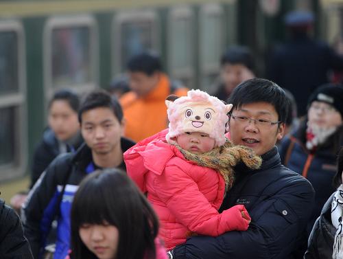 1月31日,一名旅客抱著孩子在合肥火車站進(jìn)站上車。臨近春節(jié),合肥火車站迎來節(jié)前客流高峰,預(yù)計(jì)1月31日發(fā)送旅客將突破8萬人次。目前,合肥火車站已啟用全部臨時(shí)售票窗口,使售票窗口達(dá)到171個(gè),同時(shí)加強(qiáng)安全檢查和旅客引導(dǎo)等措施,確保春運(yùn)安全。新華社記者 劉軍喜 攝