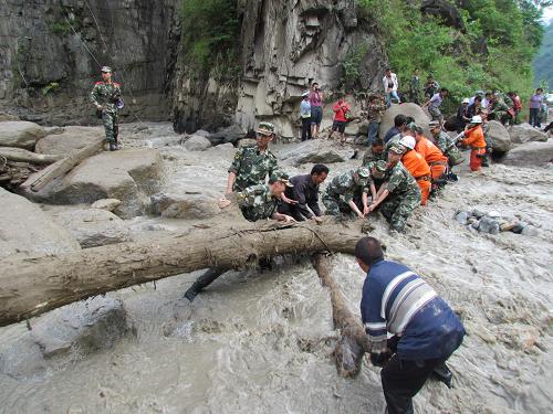 6月24日,由于貢山縣丙中洛鄉(xiāng)公路被沖毀,當?shù)剡叿?、消防人員和群眾一起用泥石流沖下來的樹干搭建便橋。6月23日下午5時10分至6時30分,云南省貢山獨龍族怒族自治縣境內發(fā)生強降雨,多條河流暴發(fā)不同程度的山洪泥石流。據初步統(tǒng)計,由于避險及時,無人員傷亡,丙中洛鄉(xiāng)安全轉移256戶679人(其中重災戶42戶,147人)。新華社發(fā)(茶志強 攝)