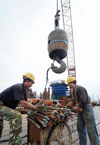 工程人員在長沙福元路湘江大橋施工現(xiàn)場吊裝建筑材料(7月12日攝)。近日,長沙市福元路湘江大橋全面進(jìn)入主橋鋼拱梁頂推施工階段。據(jù)介紹,長沙福元路湘江大橋全長約3575米,其中越江段約1435米。橋梁主跨寬達(dá)38米,按雙向六車道城市主干路設(shè)計(jì),并設(shè)置有雙向人行道。目前,大橋首個(gè)主拱開始拼裝,預(yù)計(jì)到9月中旬拼裝完畢,明年6月實(shí)現(xiàn)主橋合龍。新華社記者 龍弘濤 攝