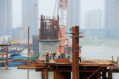 長沙福元路湘江大橋施工現(xiàn)場(7月12日攝)。近日,長沙市福元路湘江大橋全面進(jìn)入主橋鋼拱梁頂推施工階段。據(jù)介紹,長沙福元路湘江大橋全長約3575米,其中越江段約1435米。橋梁主跨寬達(dá)38米,按雙向六車道城市主干路設(shè)計(jì),并設(shè)置有雙向人行道。目前,大橋首個(gè)主拱開始拼裝,預(yù)計(jì)到9月中旬拼裝完畢,明年6月實(shí)現(xiàn)主橋合龍。新華社記者 龍弘濤 攝