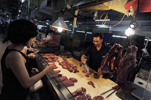 在廣州市廣大肉菜市場,顧客在購買豬肉(7月6日攝)。新華社記者 陳曄華 攝