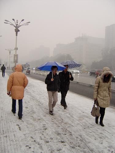12月2日,人們走在北京一處積雪覆蓋的人行道上。當日,北京降下今冬第一場雪,目前降雪仍在持續(xù)。新華社記者 徐子鑒 攝