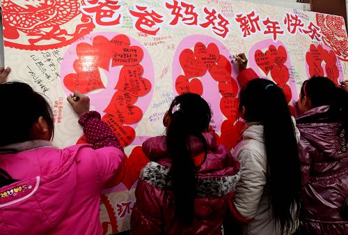 12月26日,安徽省馬鞍山市含山縣環(huán)峰第三小學(xué)留守兒童在巨型賀卡上寫滿對(duì)在外務(wù)工父母的新年祝福。當(dāng)日,安徽省馬鞍山市含山縣環(huán)峰第三小學(xué)開展留守兒童“遙寄思親情、感恩迎新年”主題活動(dòng)。留守兒童將愛心賀卡寄給在外務(wù)工的爸爸媽媽,表達(dá)對(duì)父母的感恩之情和新年祝福。新華社發(fā)(程千俊 攝)