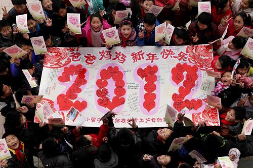12月26日,安徽省馬鞍山市含山縣環(huán)峰第三小學(xué)留守兒童在展示寫滿新年祝福的巨型賀卡。當(dāng)日,安徽省馬鞍山市含山縣環(huán)峰第三小學(xué)開展留守兒童“遙寄思親情、感恩迎新年”主題活動(dòng)。留守兒童將愛心賀卡寄給在外務(wù)工的爸爸媽媽,表達(dá)對(duì)父母的感恩之情和新年祝福。新華社發(fā)(程千俊 攝)