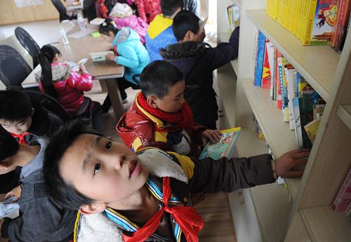 1月16日,重慶市九龍坡區(qū)西彭鎮(zhèn)的小學(xué)生在東林村“留守兒童幸福家園”借閱圖書。新華社記者 李健 攝