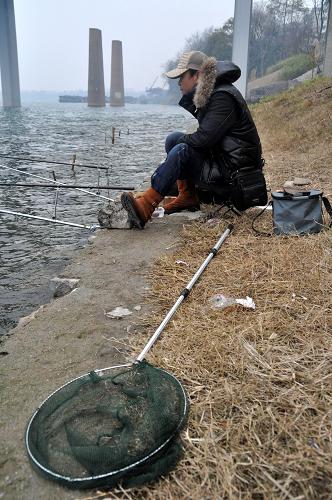 1月30日,在廣西柳州市壺西大橋下,一名市民在柳江邊釣魚。據(jù)處置龍江河突發(fā)環(huán)境事件指揮部向記者介紹,目前在柳州市區(qū)上游57公里的柳城縣糯米灘水電站以上的龍江河段,目前有鎘濃度超標5倍以上的水體長達100公里,目前柳州水源地的情況尚在控制范圍內(nèi)。新華社記者 陸波岸 攝