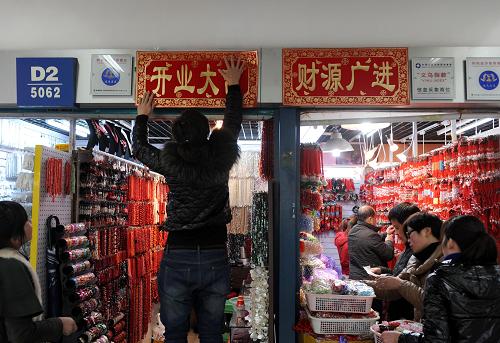 2月3日,義烏國(guó)際商貿(mào)城一名經(jīng)營(yíng)戶為攤位貼上吉祥招貼。當(dāng)日,浙江義烏中國(guó)小商品城旗下的國(guó)際商貿(mào)城、篁園服裝市場(chǎng)等在春節(jié)休市后開門迎客。2011年,義烏中國(guó)小商品城成交額515.12億元,首次突破500億元大關(guān),同比增長(zhǎng)12.95%。新華社記者 韓傳號(hào) 攝