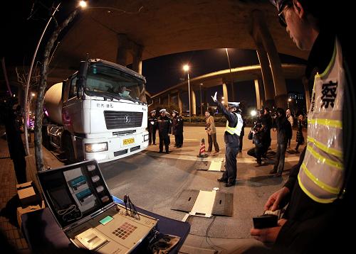 2月7日夜,交警在對(duì)一輛大型水泥攪拌車進(jìn)行稱重。從2月6日開始,上海交警部門在全市范圍內(nèi)組織開展針對(duì)大型貨運(yùn)車輛(渣土車、混凝土攪拌車、環(huán)衛(wèi)運(yùn)輸車輛等)交通違法行為的集中排查整治行動(dòng)。在為期一周的整治行動(dòng)中,交警部門將重點(diǎn)查處大型貨運(yùn)車輛超載、違反交通信號(hào)、故意遮擋、污損號(hào)牌等嚴(yán)重交通違法行為,以及非機(jī)動(dòng)車超越行車線、闖紅燈、逆向行駛和行人闖紅燈等容易引發(fā)涉及大型貨運(yùn)車輛人員傷亡交通事故的交通違法行為。新華社記者 凡軍 攝