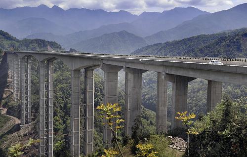 崇山峻嶺中的臘八斤特大橋全貌(4月18日攝)。4月28日,雅西高速全線建成通車,當(dāng)車輛行走在200多米高的臘八斤特大橋面上時,如同在云霧中徜徉。臘八斤特大橋位于四川省滎經(jīng)縣石滓鄉(xiāng)境內(nèi),全長1106米,該橋高230米,最高橋墩(10號橋墩)高182.6米。這里地形陡峭,巖層硬度低,降雨量大,地質(zhì)環(huán)境復(fù)雜,施工單位建設(shè)橋梁時首創(chuàng)了“鋼管疊合柱”橋墩、C80號混凝土自密實澆筑工藝。它的建成為我國西部山區(qū)復(fù)雜地形條件下高速公路橋梁建設(shè)作出了有益嘗試。新華社記者 江宏景 攝